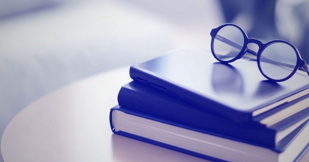 Une paire de lunettes posée sur une pile de livres