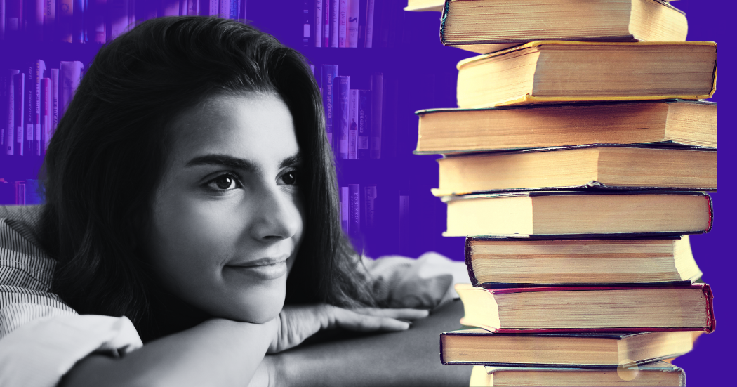 Jeune femme motivée devant une pile de livres à lire