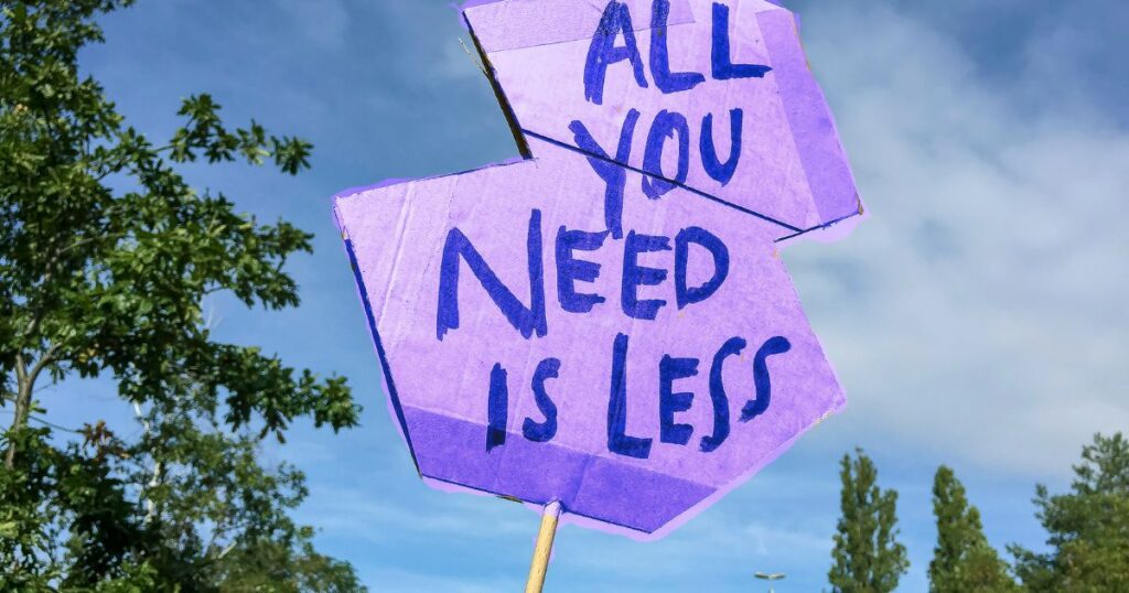 Panneau artisanal affichant l "All you need is less"