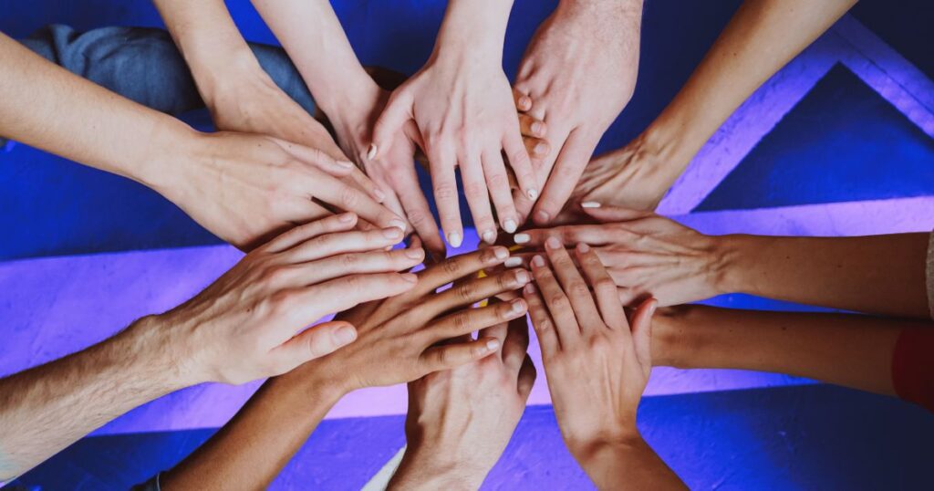 Des mains les unes sur les autres pour symboliser la collaboration entre blogueurs pour une meilleure visibilité