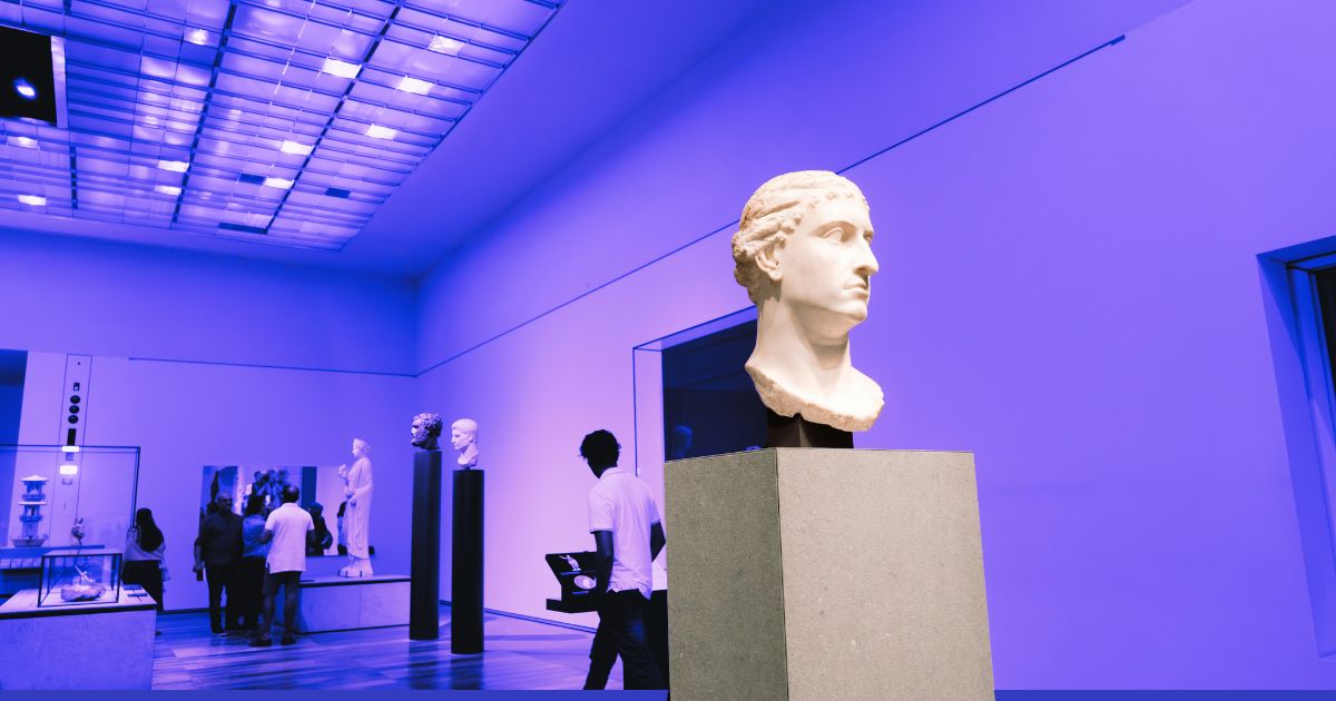 Des personnes visitent une salle de musée antique