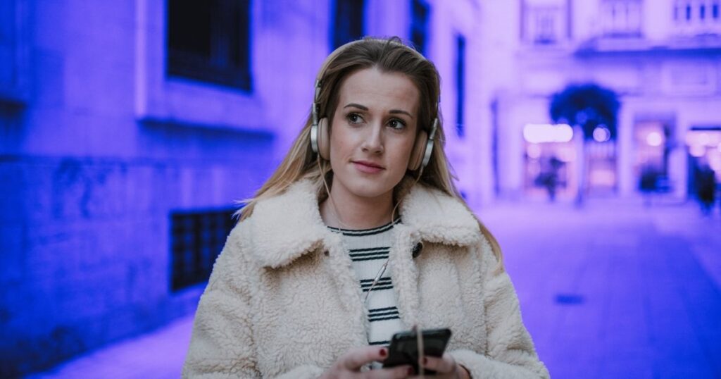 Une femme écoute un podcast en marchant dans la rue