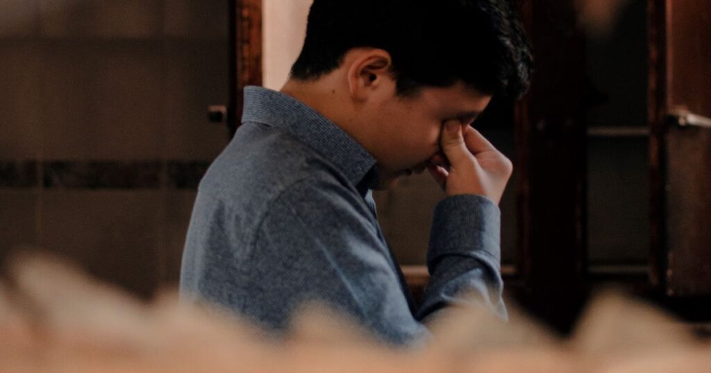 Un jeune homme a les doigts sur les yeux, parce qu'il se sent inculte