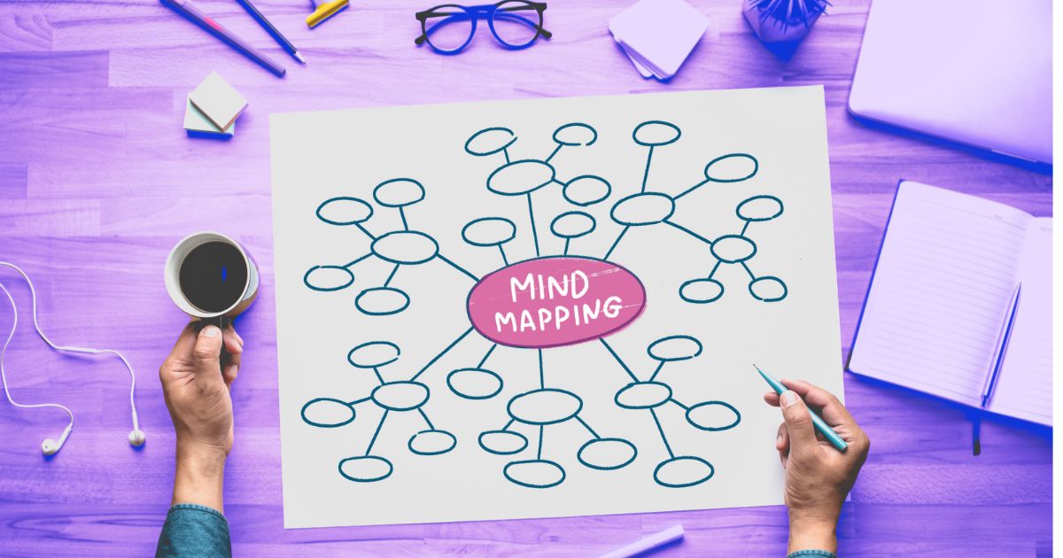 Une main tient un stylo, l'autre une tasse de café, sur une carte mentale