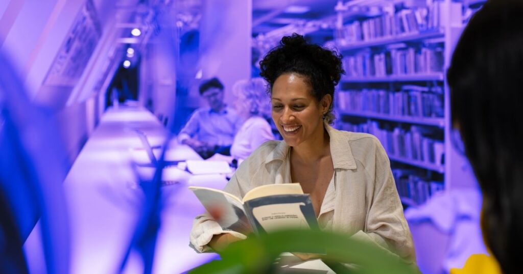 Femme souriante dans une bibliothèque