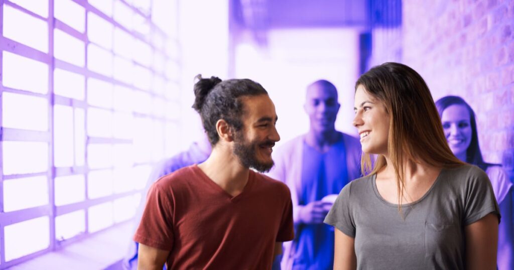 Deux personnes discutent dans un couloir fréquenté