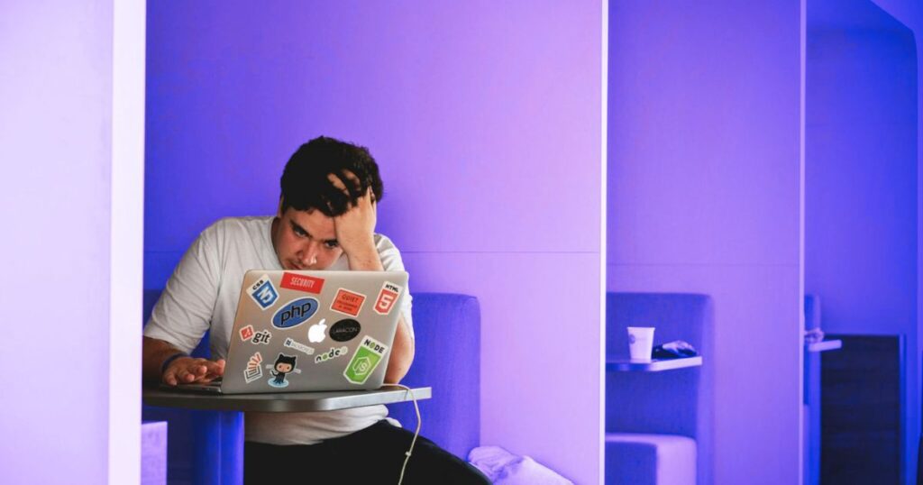 Un homme devant son ordinateur portable fait l'effort de s'intéresser