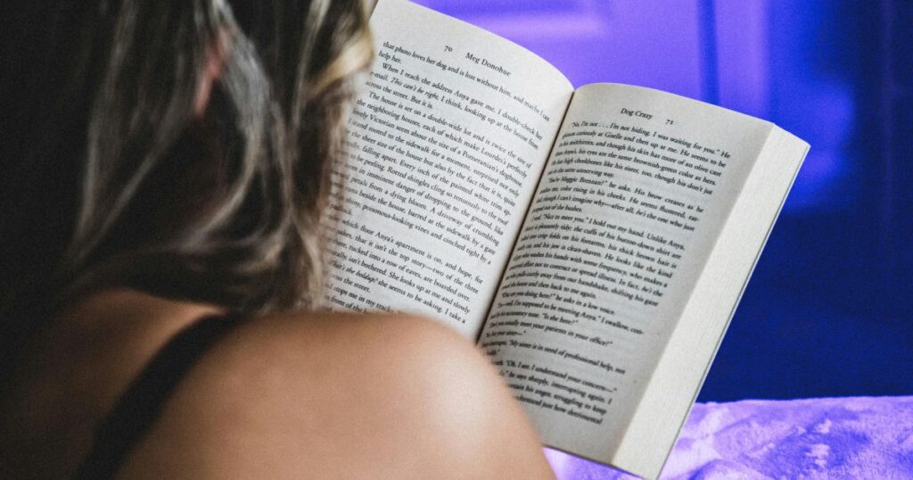 Gros plan d'une femme vue de dos en train de lire un livre