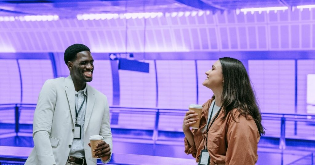 Un homme et une femme sur un quai de métro conversent en riant