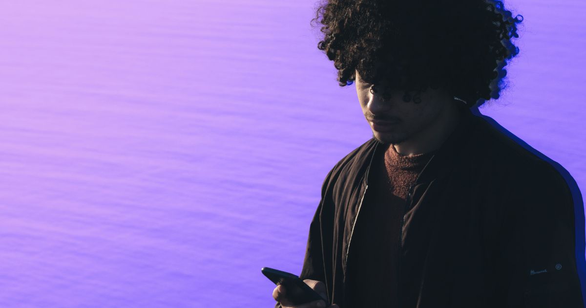 Un jeune homme lit un contenu sur son smartphone